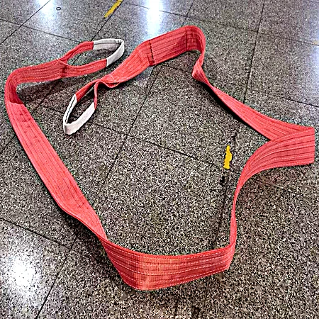 Heavy duty eye and eye flat web sling in red shown along its full length