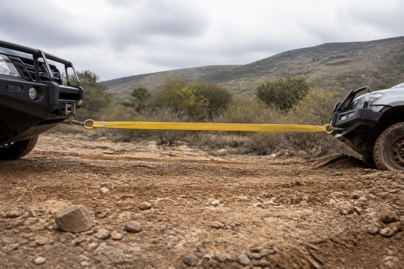 Golden aramid webbing recovery strop under tension between a recovery vehicle and a bogged vehicle