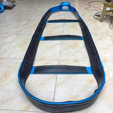 Glass lifting sling with blue edging and three horizontal cross bars laid out on a factory floor
