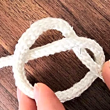 White braided fiberglass sealing rope tied in a knot to show flexibility and small bend radius