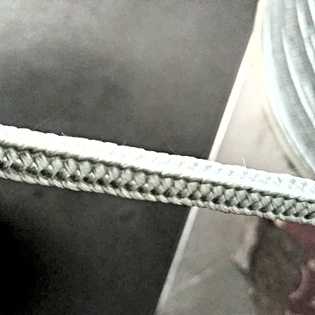 Square braided fiberglass sealing rope seated in the groove of a cast iron stove door