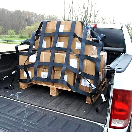 Black truck cargo net over a pallet of cartons in a silver pickup truck