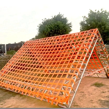 Orange webbing climbing net fitted to a steel A-frame in a park