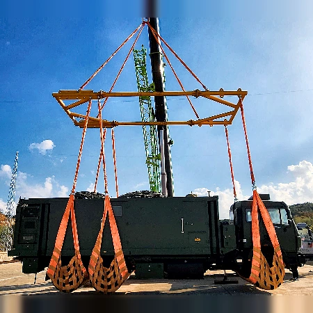 Double beam spreading frame with polyester webbing slings lifting a heavy vehicle