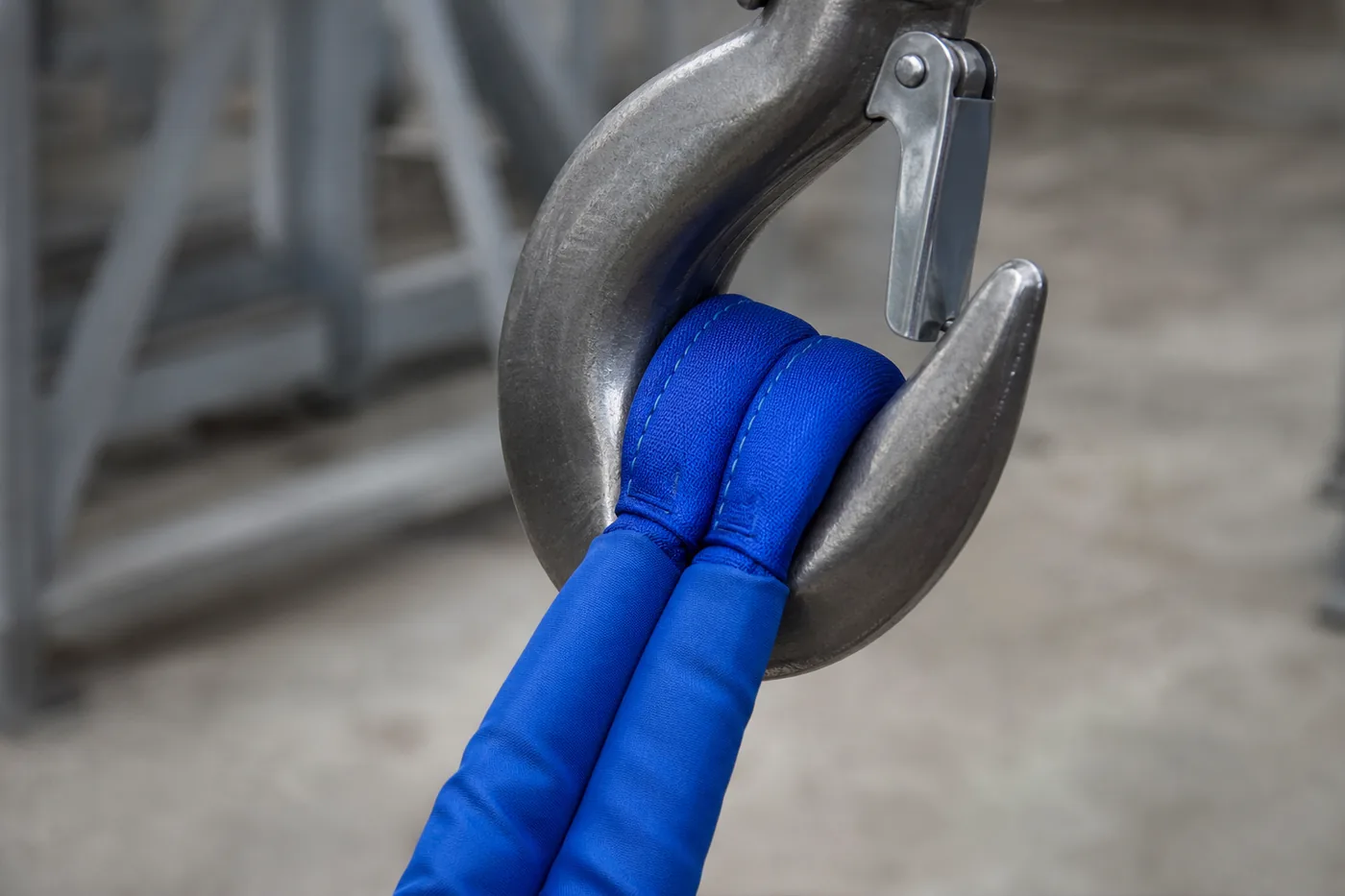 Two blue eye and eye round slings in basket arrangement lifting a welded steel frame in a fabrication hall
